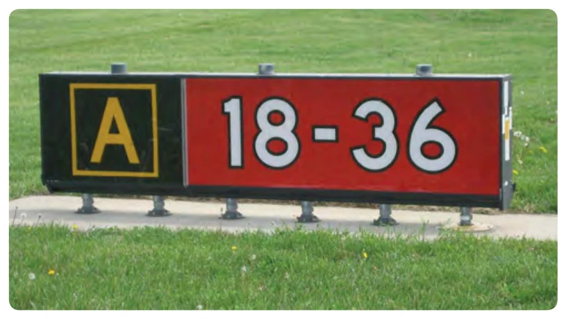 Runway holding position sign at a location other than the takeoff end of Runway 18-36 with collocated Taxiway Alpha location sign.